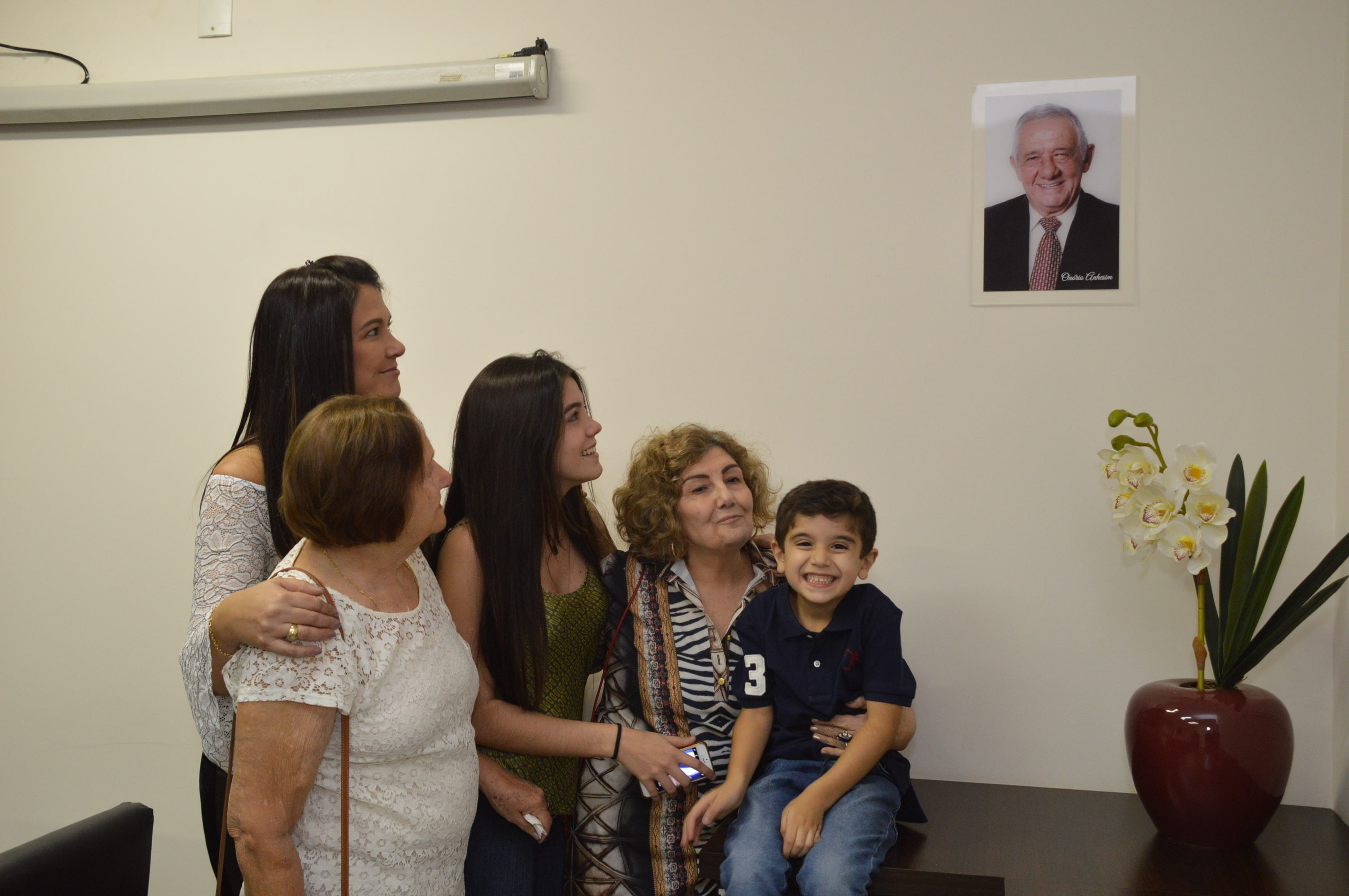 Familia Anhesim e a foto de Onorio na Sala de Reunioes